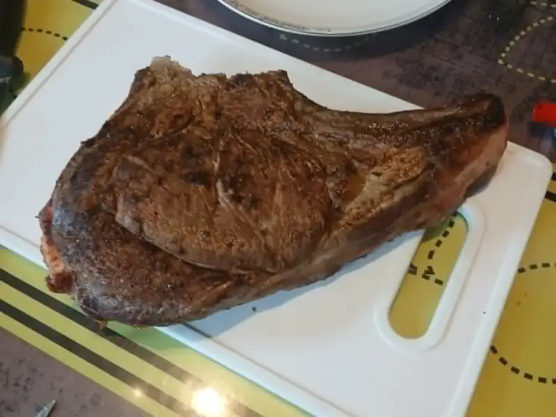 Seared bone-in rib steak on a white cutting board