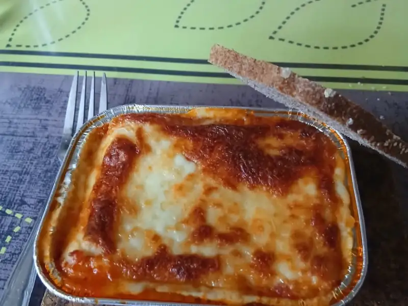 Homemade individual lasagna: a nicely browned foil pan with a slice of toast