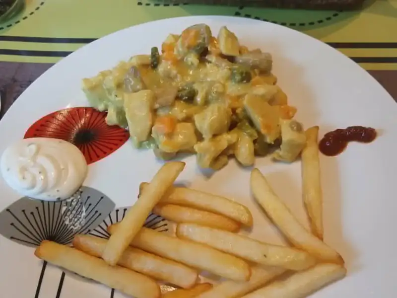 Quick vol-au-vent with chicken, mushrooms, carrots and peas in turmeric sauce, served with fries and mayonnaise